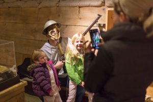 Mom taking picture of her kids dressed up as soldiers