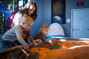 photo of mother and children digging for fossils