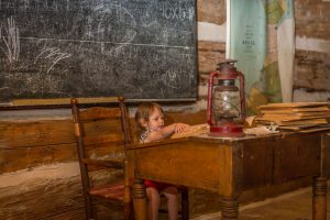 Photo of child at desk in school house