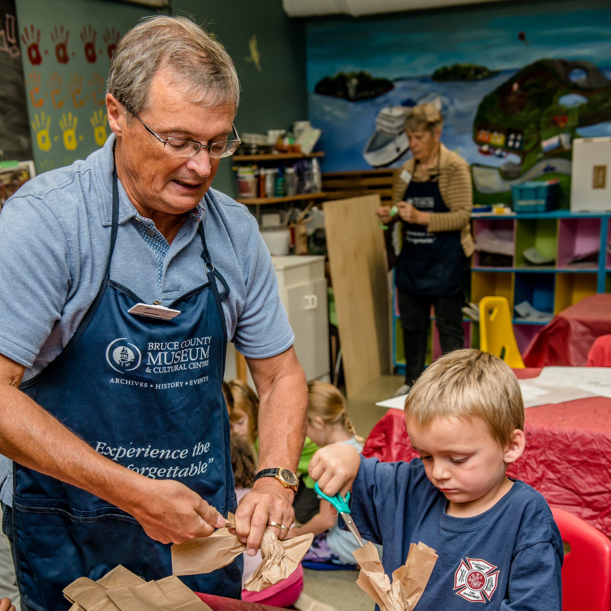 photo of a man helping a boy with a craft