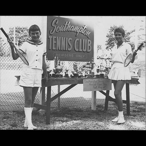 Two tennis players posing with trophies