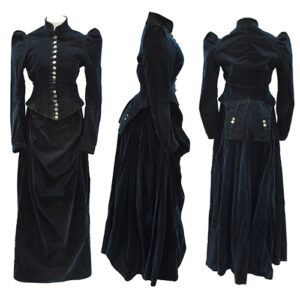 A Victorian-era jacket and skirt in navy blue velvet. The jacket has silver buttons up the front and split coattails at the back.