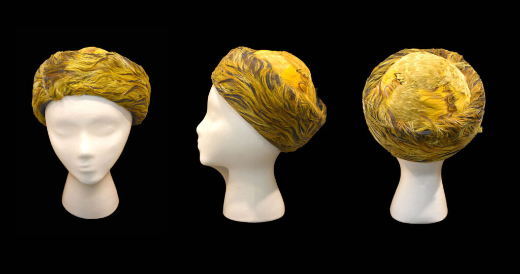 Yellow feather hat on a fake white head.