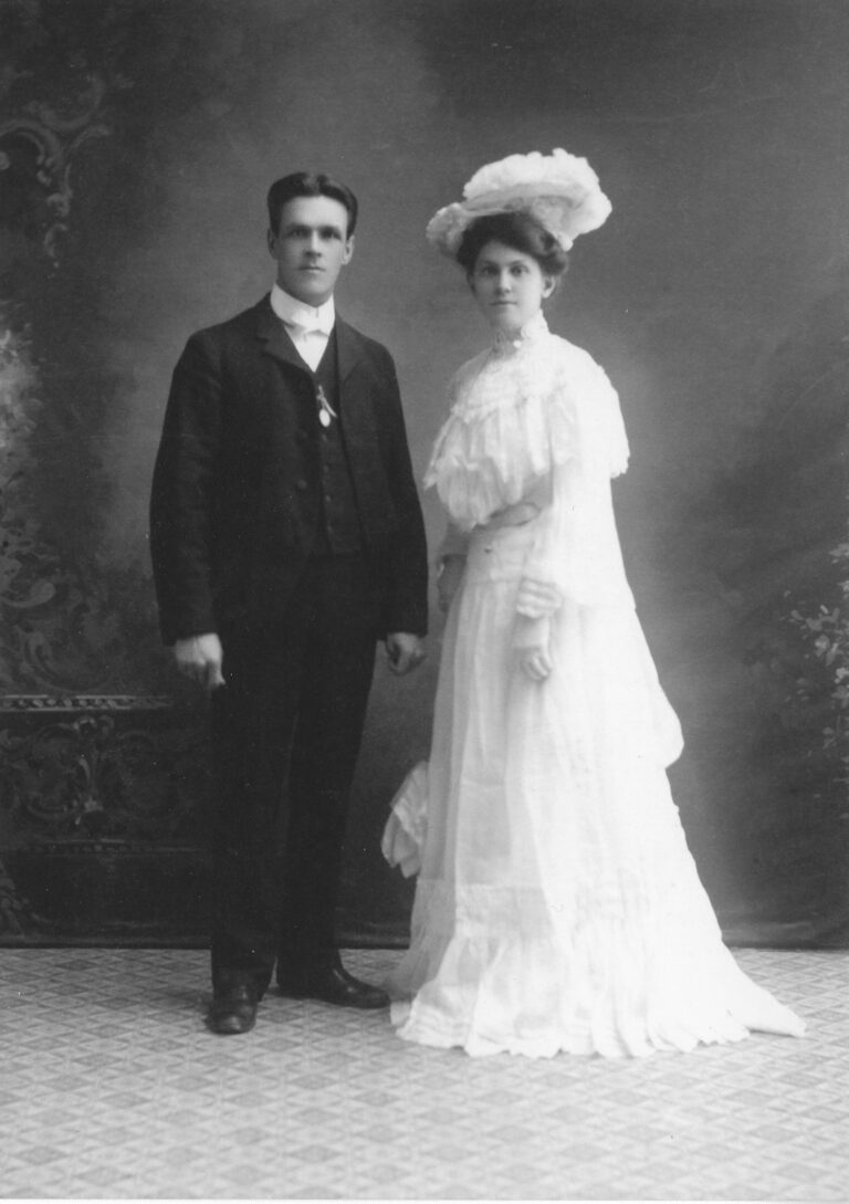 Two people, bride and groom, standing for a photo