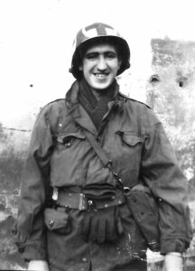 Historic black-and-white photograph of Sergeant Medic Alex Barris, father of author Ted Barris, standing in military uniform and a medic helmet marked with a red cross during the Second World War.